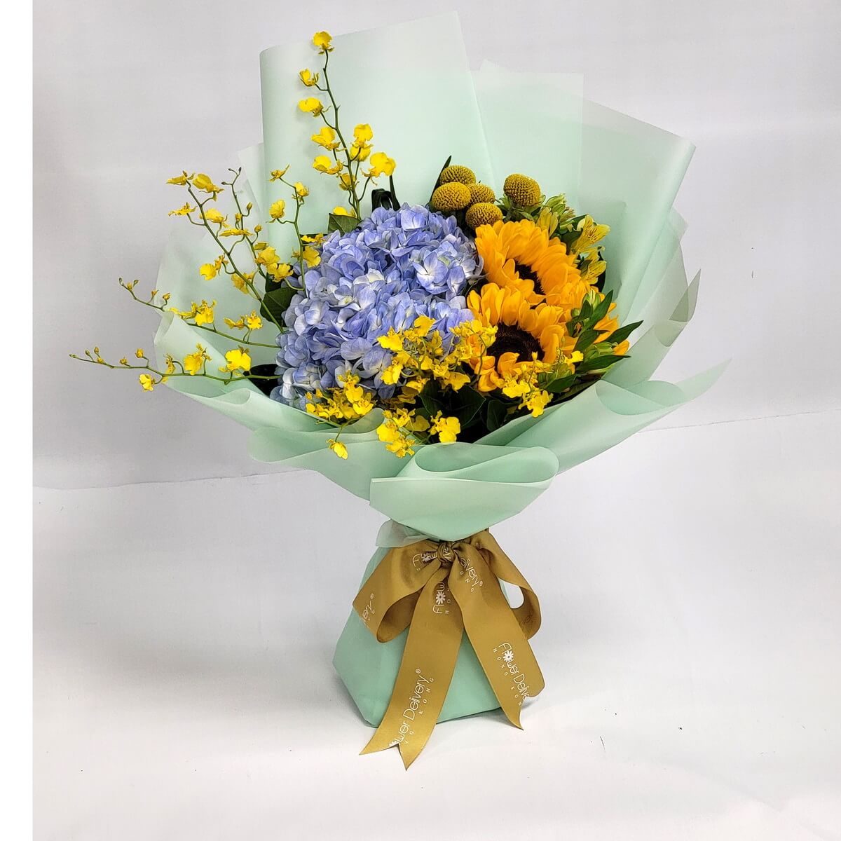 Bright bouquet of sunflowers, blue hydrangeas, yellow dancing orchids, and craspedia, wrapped in soft mint green paper with a golden ribbon. 青綠包裝搭配向日葵、藍繡球與跳舞蘭，清爽活力十足。