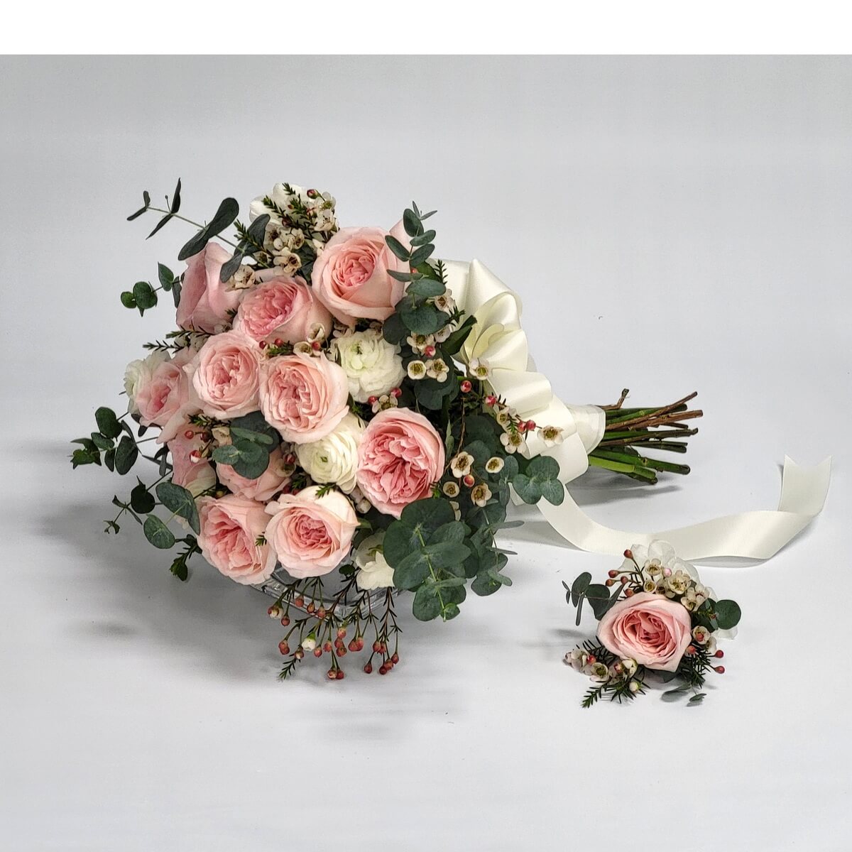 Elegant bridal bouquet with blush garden roses, ranunculus, wax flowers, eucalyptus, and berries, with matching boutonniere. 高雅新娘花球，配以粉紅花園玫瑰、白洋牡丹、蠟花、尤加利與紅果，附同款襟花。