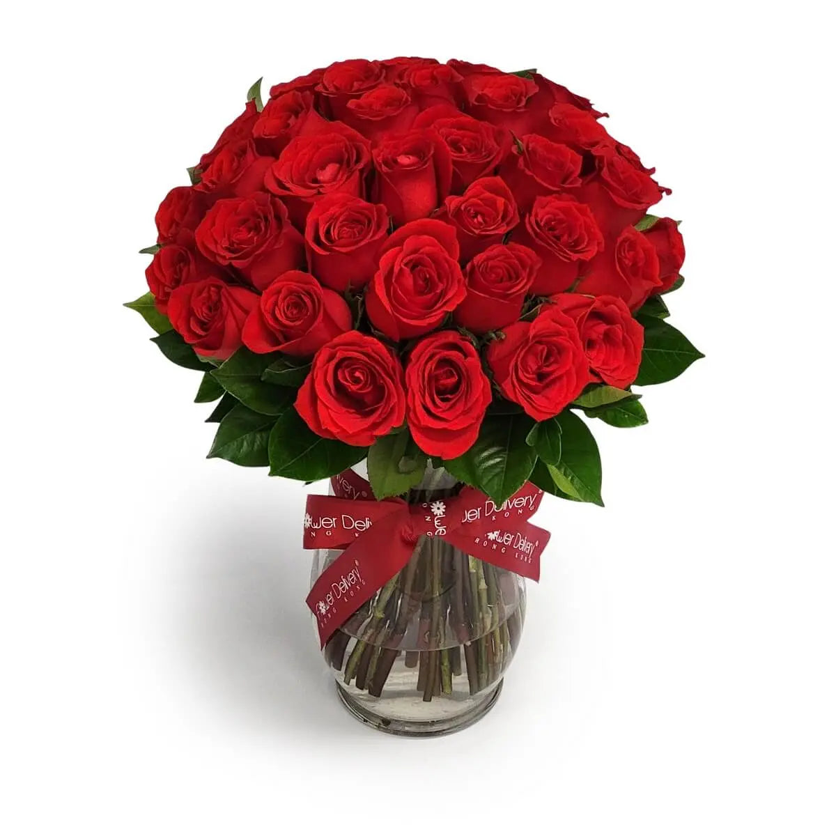 Full arrangement of red roses and green leaves displayed in a round clear glass vase with a red ribbon. | 大束紅玫瑰與綠葉插於透明圓形玻璃瓶中，以紅色絲帶綁飾。
