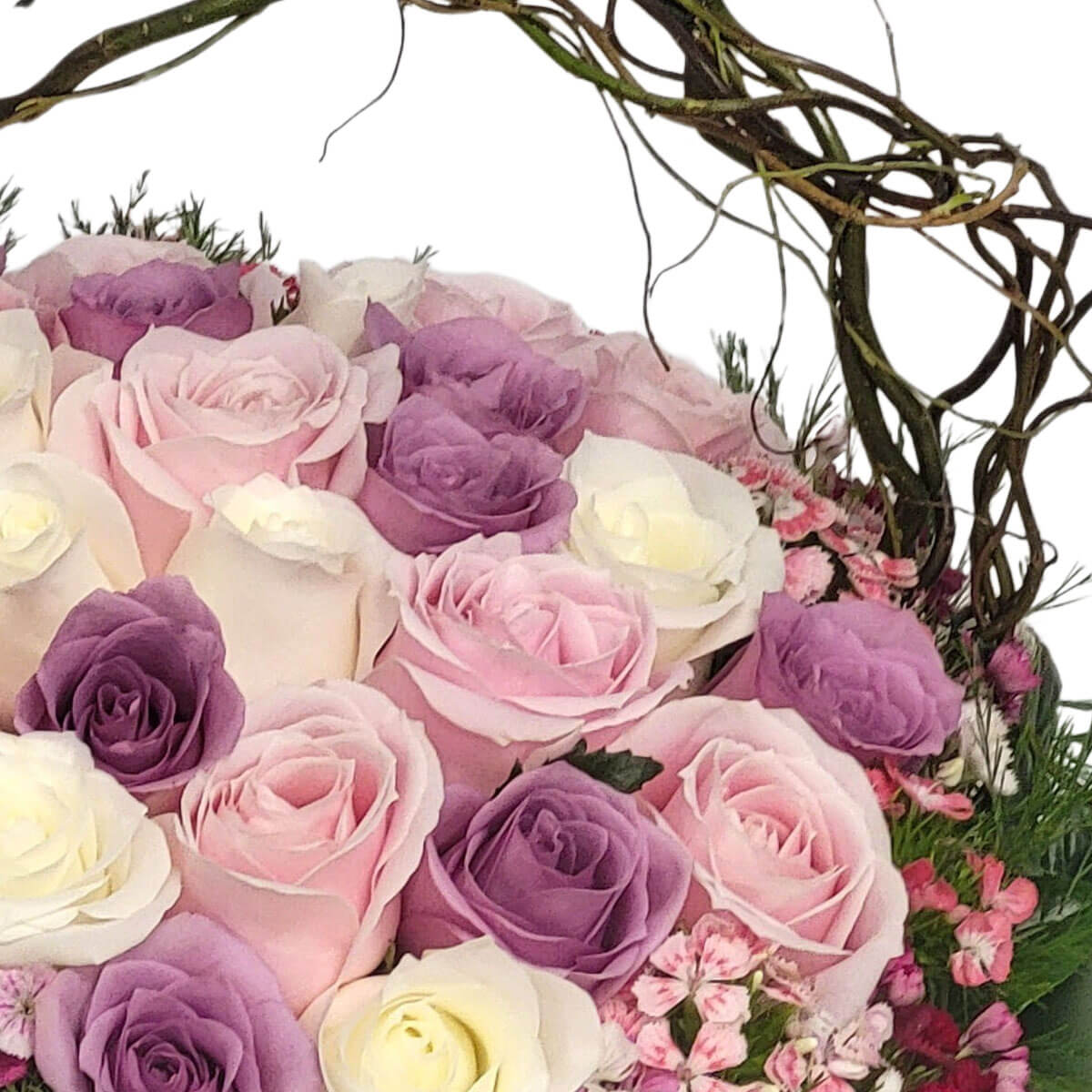 Arrangement of pink, lavender, and ivory roses with pink dianthus in a rustic vine-handled basket 粉紅、紫色與奶白玫瑰搭配粉色石竹花，置於藤枝花籃中，營造自然鄉村風。