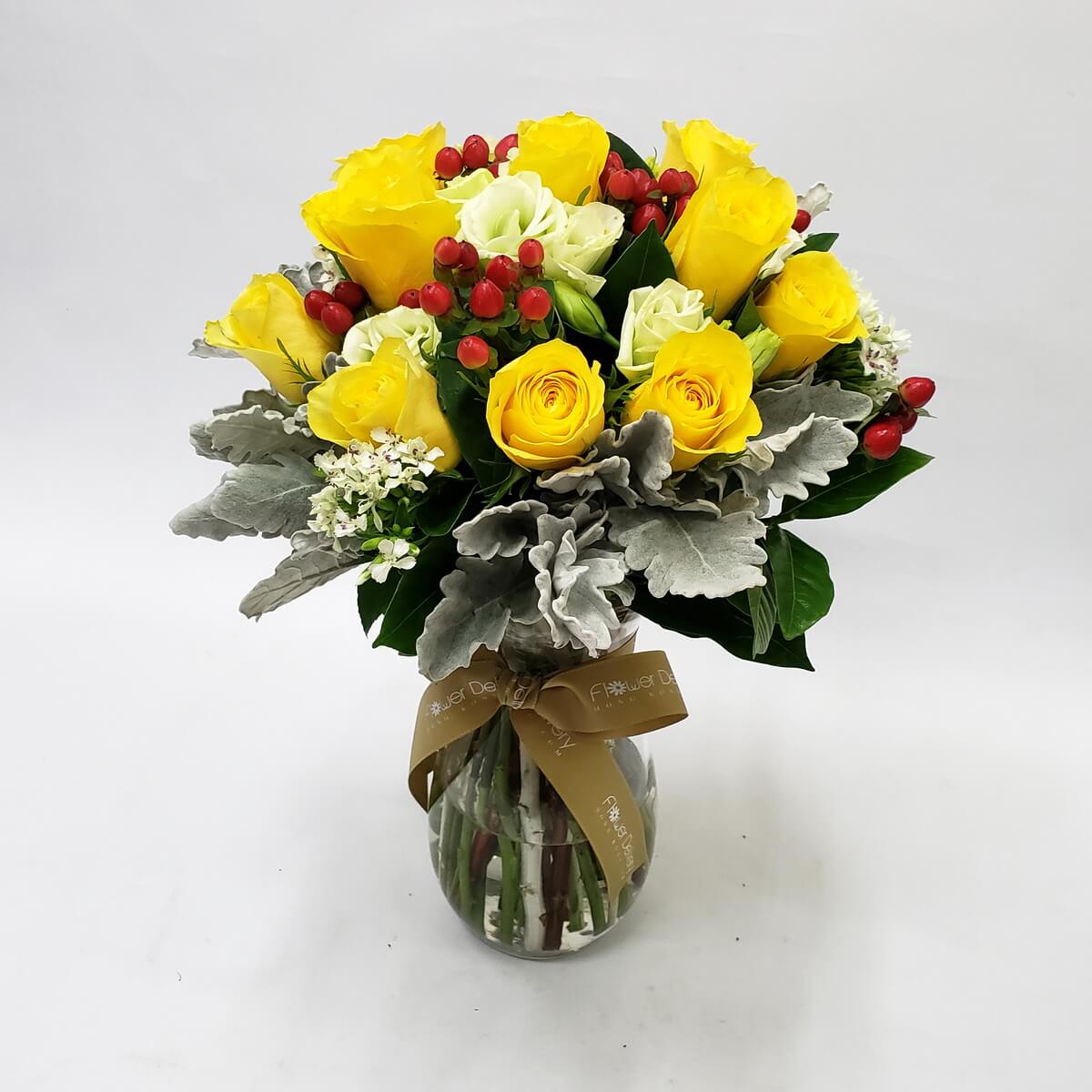 Original photo of vase arrangement of yellow and white roses, red hypericum berries, white filler flowers, dusty miller, and mixed foliage in a clear round glass vase - 黃白玫瑰、紅色小果、白配花、銀葉菊及襯葉圓形玻璃瓶插花