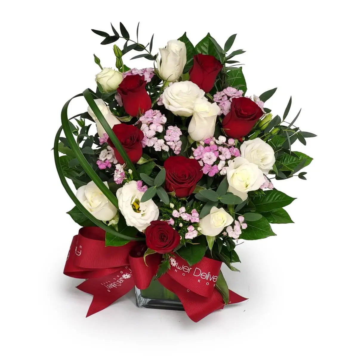 Floral arrangement in glass vase with red and white roses, white lisianthus, pink dianthus, and mixed foliage. 紅白玫瑰、白洋桔梗及粉石竹花搭配綠葉，置於玻璃瓶內，配紅絲帶點綴。