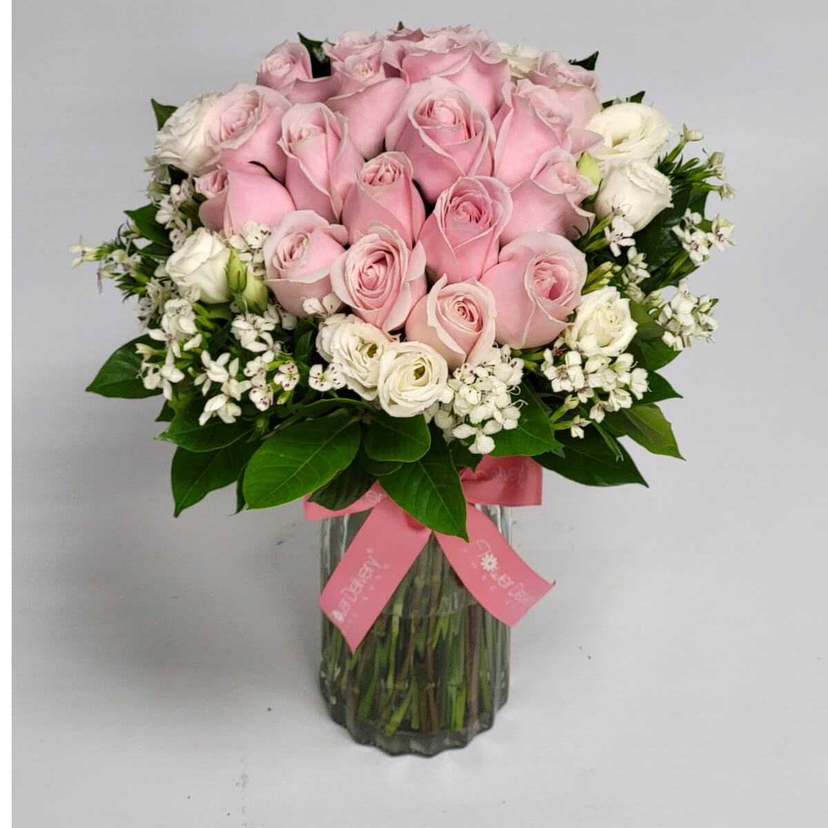 Charming bouquet of soft pink and white blooms in a vase 柔美粉紅玫瑰搭配白色小玫瑰與襯花，玻璃瓶插花設計，粉紅絲帶點綴，溫柔又優雅。