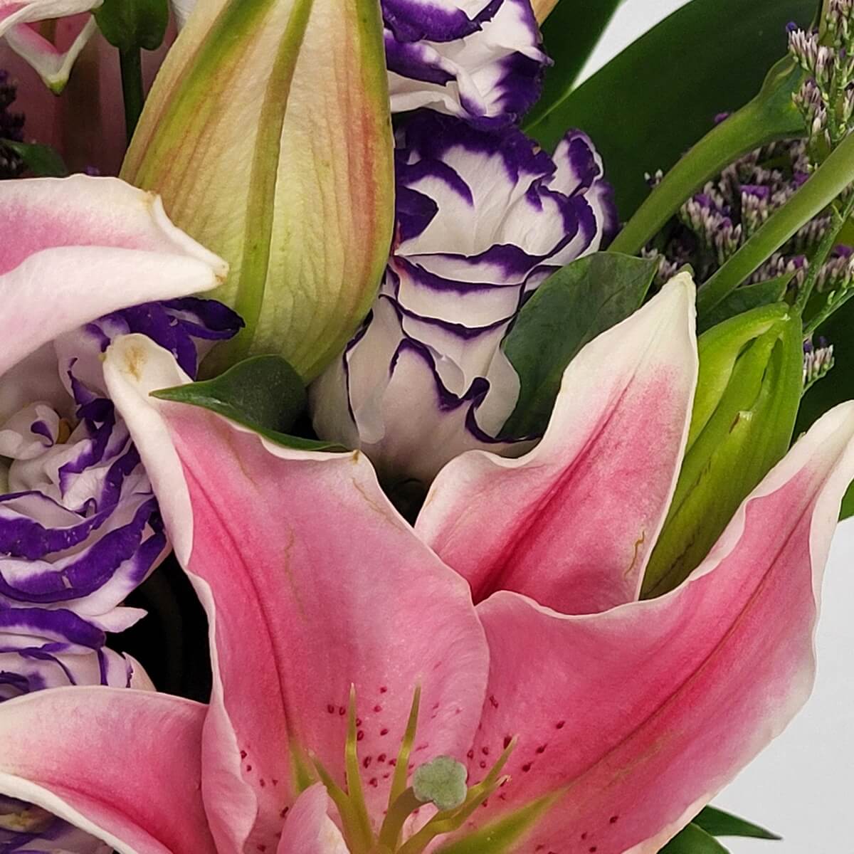 Zoomed-in view of blooming pink lily beside curled-edge lisianthus and closed buds - 盛開粉百合、捲邊洋桔梗與花苞特寫