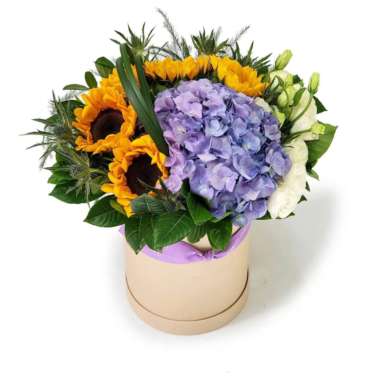 Beige hatbox with sunflowers, purple hydrangeas, white eustomas, and assorted foliage | 米色花盒盛載向日葵、紫色繡球花、白色桔梗與綠色葉材，色彩層次豐富。