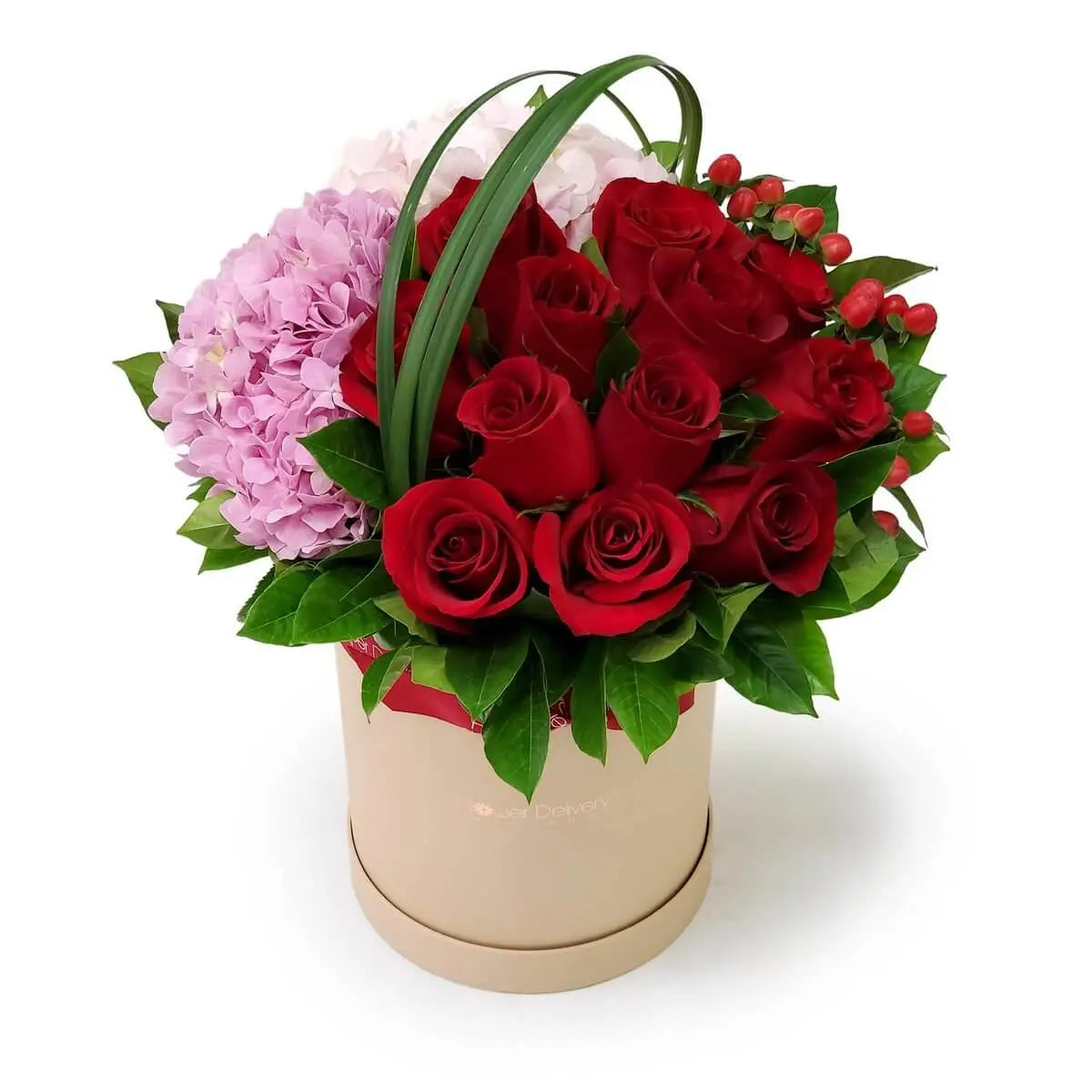 Round hatbox filled with red roses, pink and lilac hydrangeas, red hypericum berries, and green foliage | 圓形花盒設計，內有紅玫瑰、粉紫繡球花、紅色聖誕果及亮綠葉材組成的豐盈花藝作品