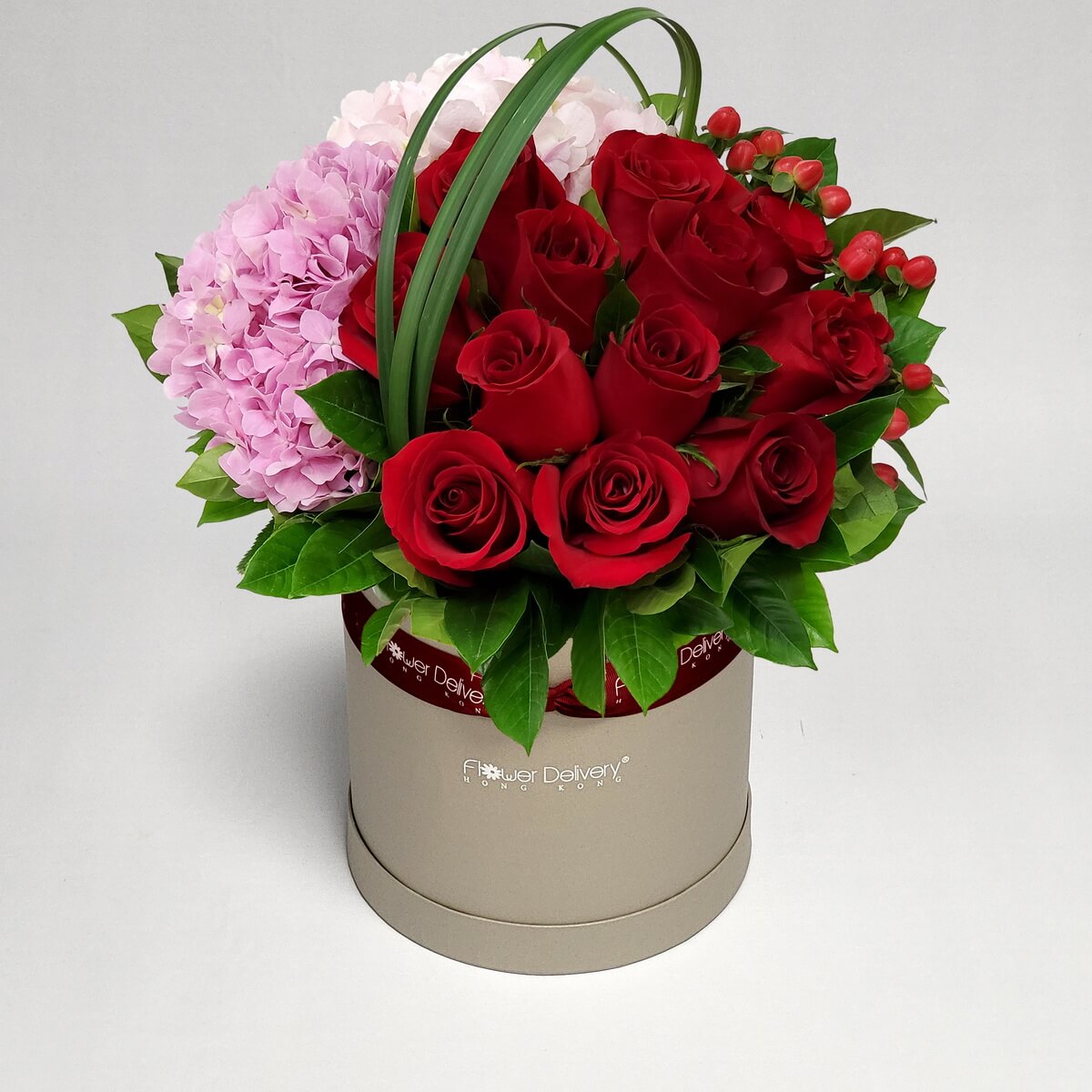 Authentic photo of round hat box flower arrangement with red roses and pink hydrangea with green foliage - 紅玫瑰與粉紅繡球花帽盒花藝設計配綠葉