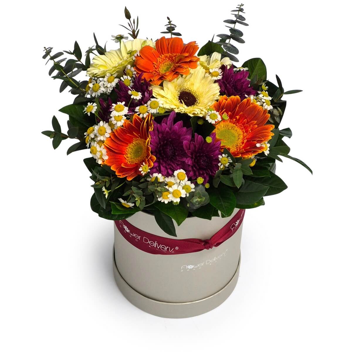 Bloom box floral arrangement with orange and yellow gerbera daisies, purple chrysanthemums, chamomile daisies and foliage - 橙黃非洲菊配紫色菊花、洋甘菊小花及綠葉圓形花盒花藝