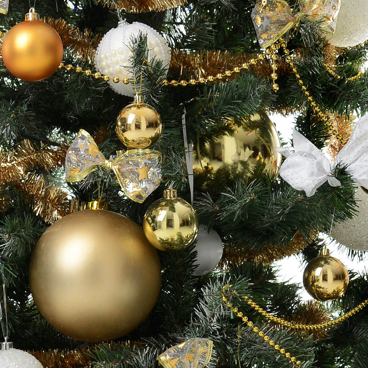 A close-up of a festive Christmas tree decorated with shiny gold and white baubles, delicate bows, and sparkling garlands – 聖誕樹特寫，飾以閃亮金白球、精緻蝴蝶結與金色亮片串營造節慶氣氛
