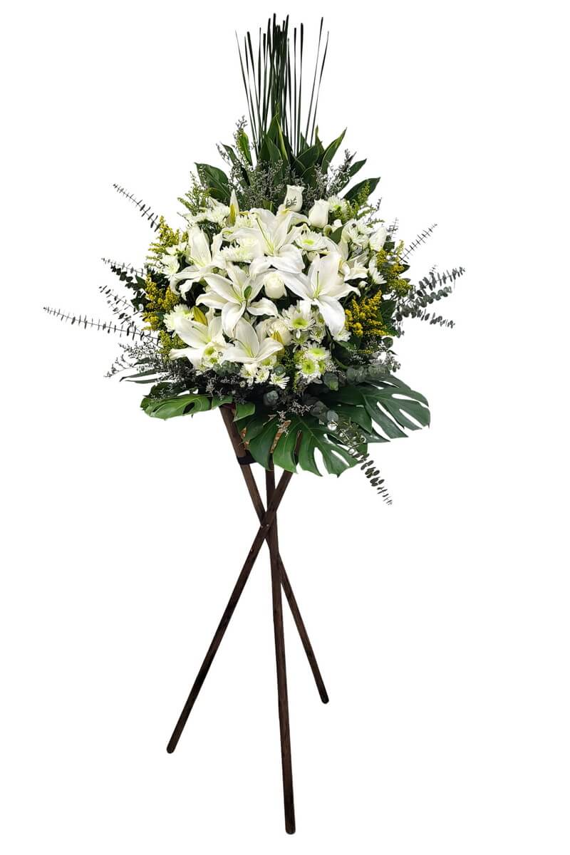 Full standing arrangement featuring white lilies, roses, green-centered button chrysanthemums, yellow solidago, eucalyptus and monstera leaves 高架花牌包含白色百合、玫瑰、綠心乒乓菊、黃莖花、尤加利及龜背葉