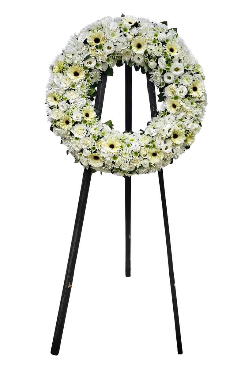 Full floral wreath with white gerberas, roses, lisianthus, and button chrysanthemums on a black tripod stand - 白色太陽菊、玫瑰、洋桔梗及乒乓菊圓形花圈配黑色三腳支架擺放