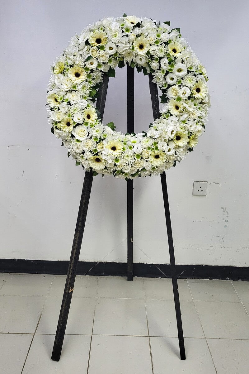 Complete white floral wreath with gerberas, roses, lisianthus, disbud and spray chrysanthemums with green centers, and carnations on black stand - 白色太陽菊、玫瑰、洋桔梗、大頭及綠芯小朵菊花配康乃馨圓形花圈連黑色支架