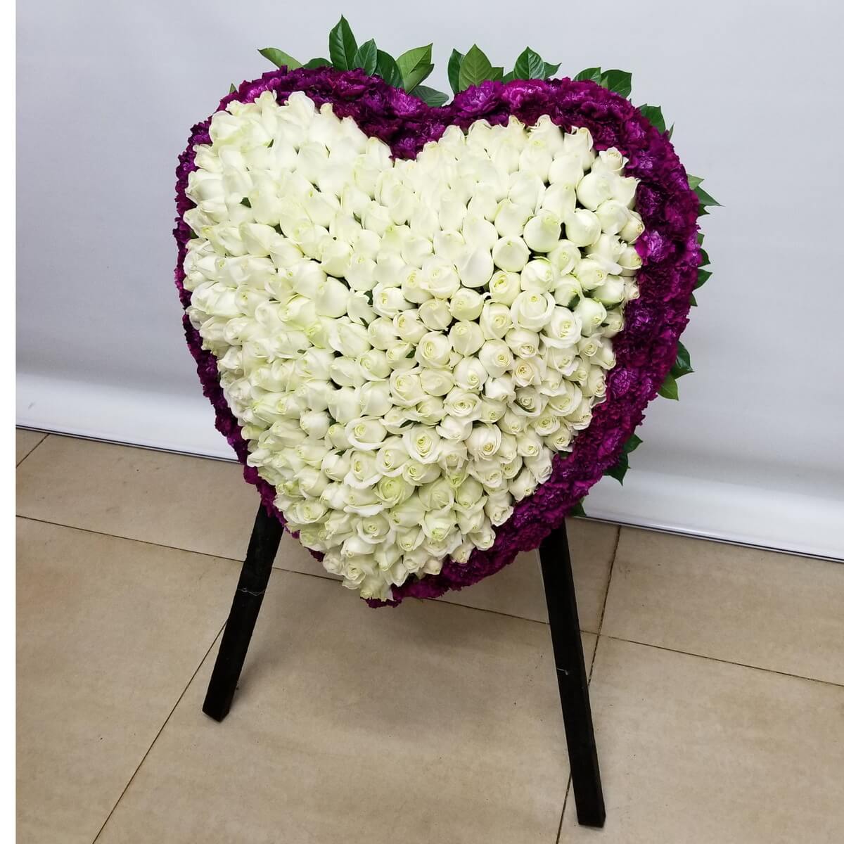 Original standing heart-shaped floral arrangement composed of layered white roses, framed by ruffled purple carnations and greenery - 站立式心形花牌，以層次白玫瑰組成，邊框為紫色皺瓣康乃馨與綠葉點綴