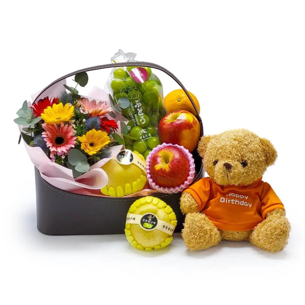 Hamper with mixed gerbera bouquet, apples, Korean pears, grapes, citrus fruits, and a plush bear in “Happy Birthday” shirt | 太陽花花束配蘋果、韓國香梨、青提子、柑橘水果，附橙色「生日快樂」字樣毛公仔，氣氛溫馨愉快。