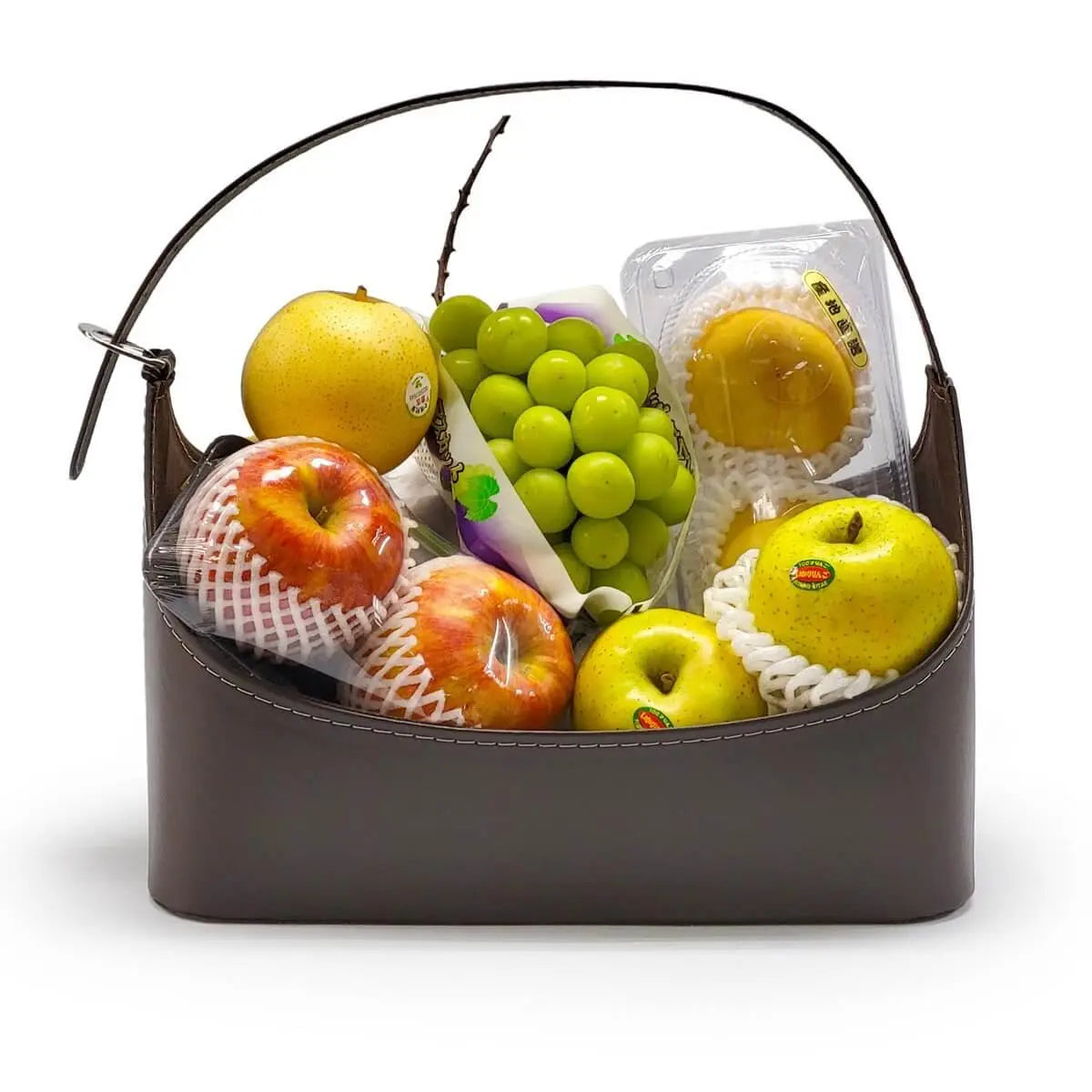 Assorted fruit basket with green grapes, Fuji apples, golden apples, and pears in dark brown handled container. 多款水果包括青提子、富士蘋果、金蘋果及香梨，盛載於深啡色手提皮籃中。