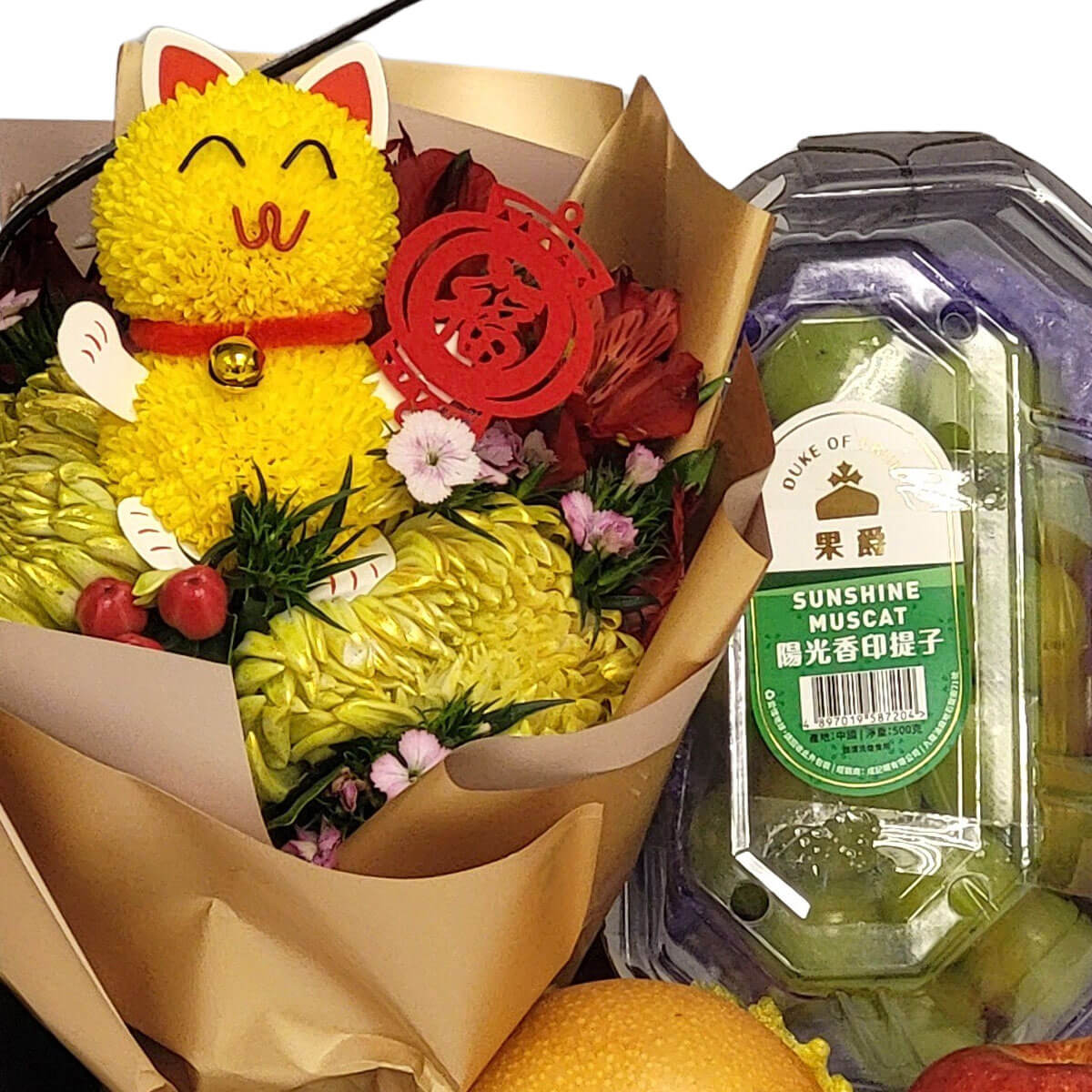 Festive bouquet with yellow chrysanthemums, lucky cat pompom, and fresh Sunshine Muscat grapes 黃菊與招財貓組成的花束，搭配新鮮陽光香印提子，象徵好運與豐收。