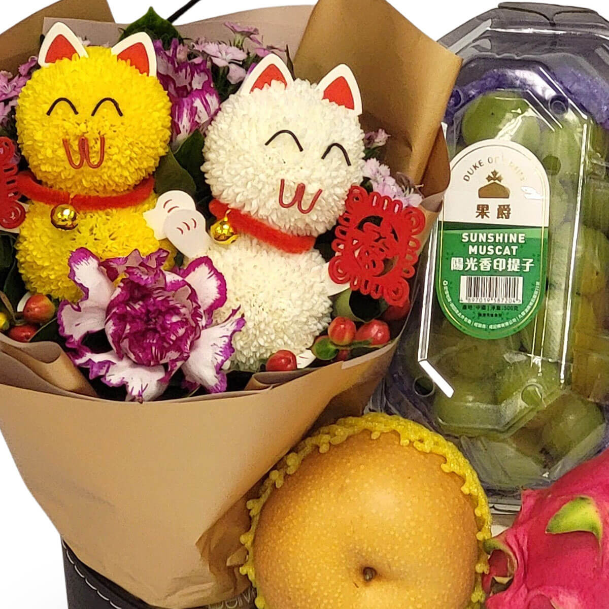 Bouquet with yellow and white lucky cats, carnations, and fruits including Sunshine Muscat grapes, Asian pear, and dragon fruit 雙色招財貓花束配洋桔梗與水果：香印提子、水晶梨與火龍果，喜氣滿滿。