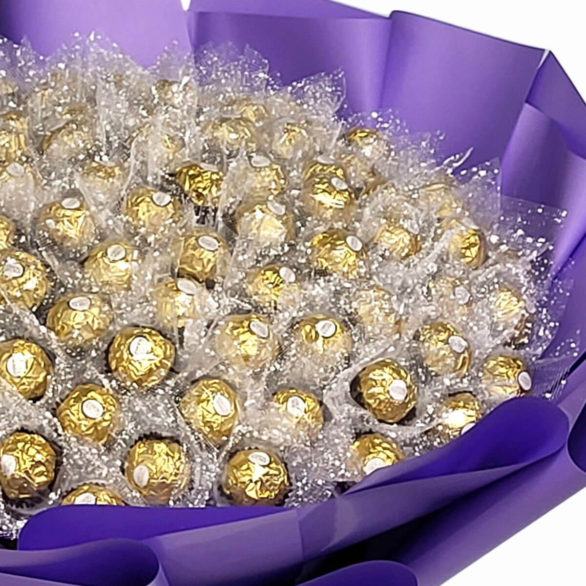 A stunning chocolate bouquet of Ferrero Rocher in gold wrap and purple paper, perfect for gifting 費列羅金莎巧克力打造的花束，金色包裝配紫色紙藝，送禮體面又甜蜜。