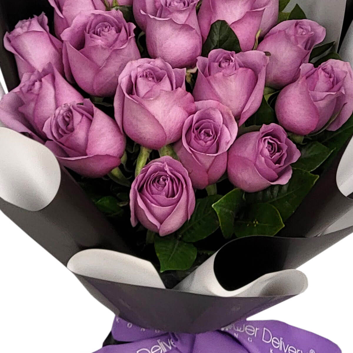 Charming bouquet of purple roses nestled in glossy green leaves, wrapped in sleek black and white paper – 迷人紫玫瑰與綠葉相襯，黑白包裝紙展現高雅氣質