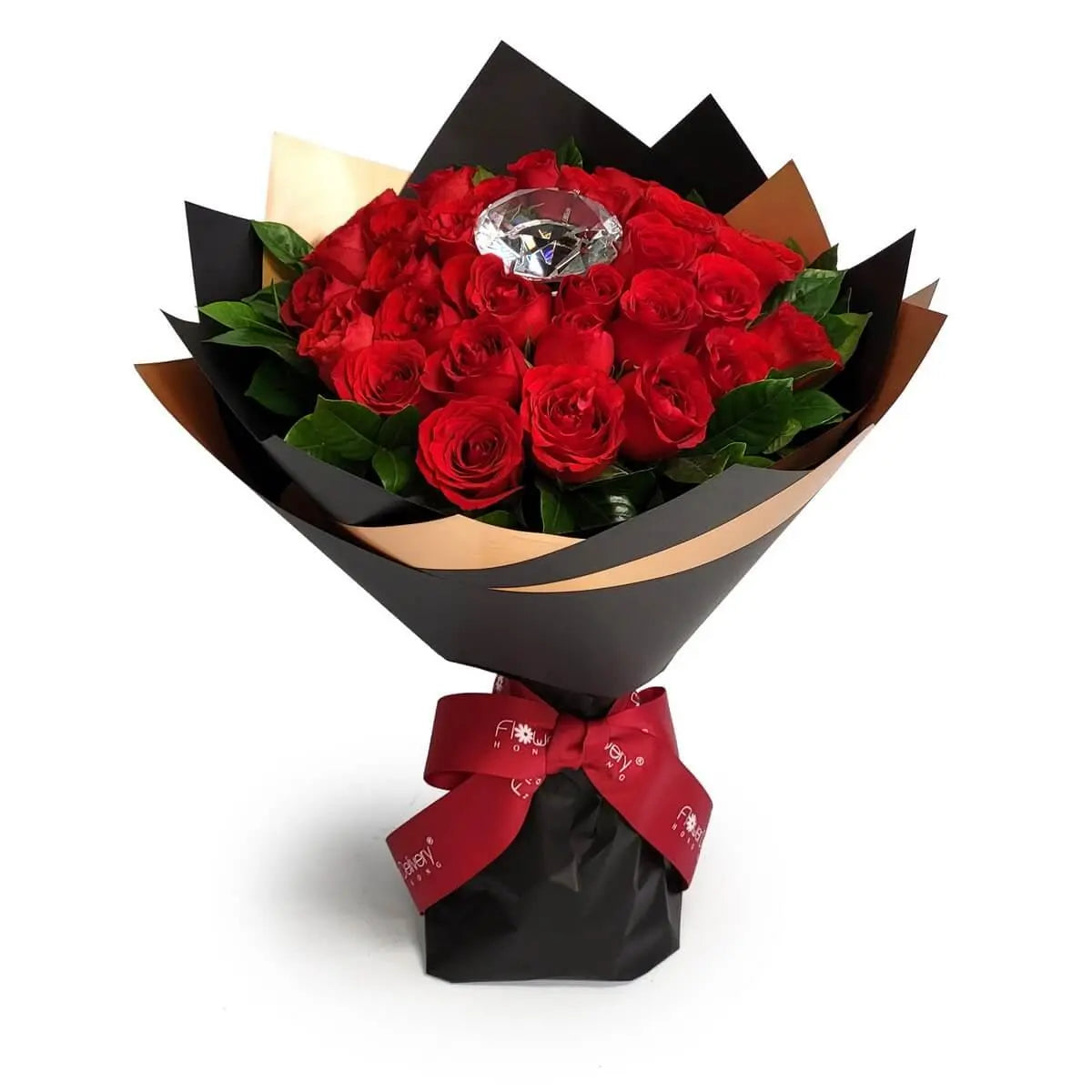 Lush red rose bouquet with glossy foliage, topped with a large faux diamond accent, wrapped in matte black and bronze paper with a deep red ribbon | 紅玫瑰與亮綠葉材組成的花束，中央飾以大型仿鑽石，配啞黑與金銅色包裝紙及深紅絲帶收束。