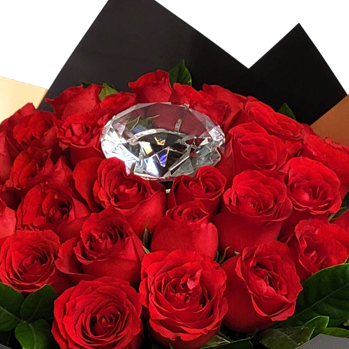 A stunning bouquet of red roses adorned with a brilliant diamond-like crystal centerpiece 綻放的紅玫瑰間嵌著閃耀水晶，寓意堅貞不渝的愛與高貴的心意。