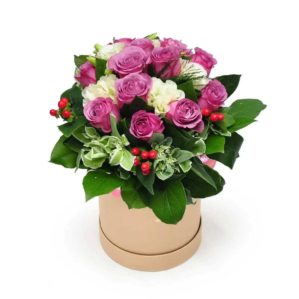 Mauve roses and white lisianthus arranged with red berries and green foliage in a beige round box. 淺紫玫瑰與白洋桔梗搭配紅色果實及綠葉，擺放於米色圓形花盒內。