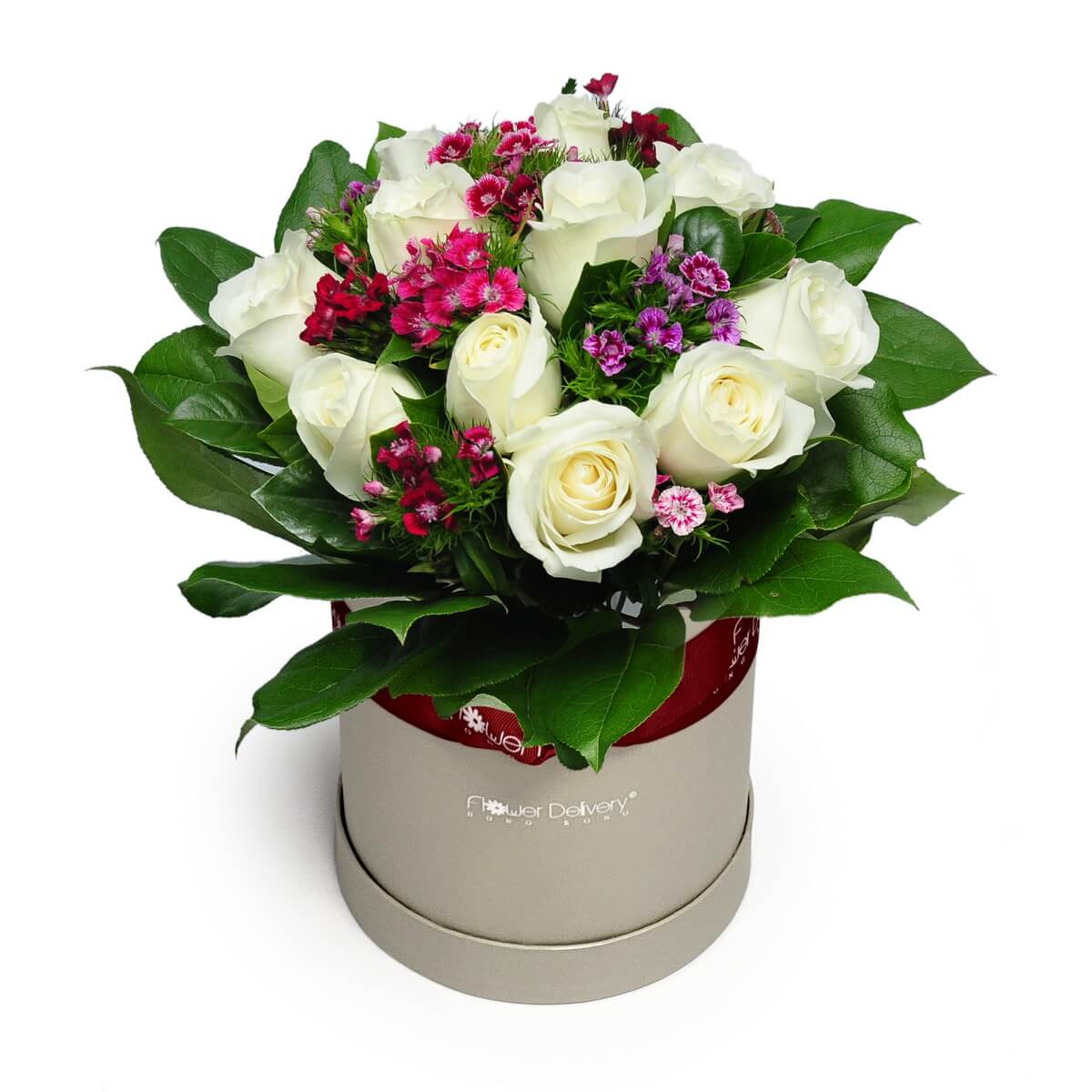 Floral box featuring white roses accented with pink and purple dianthus blooms and lush green leaves - 白玫瑰搭配粉紅與紫色石竹花及濃密綠葉圓形花盒設計