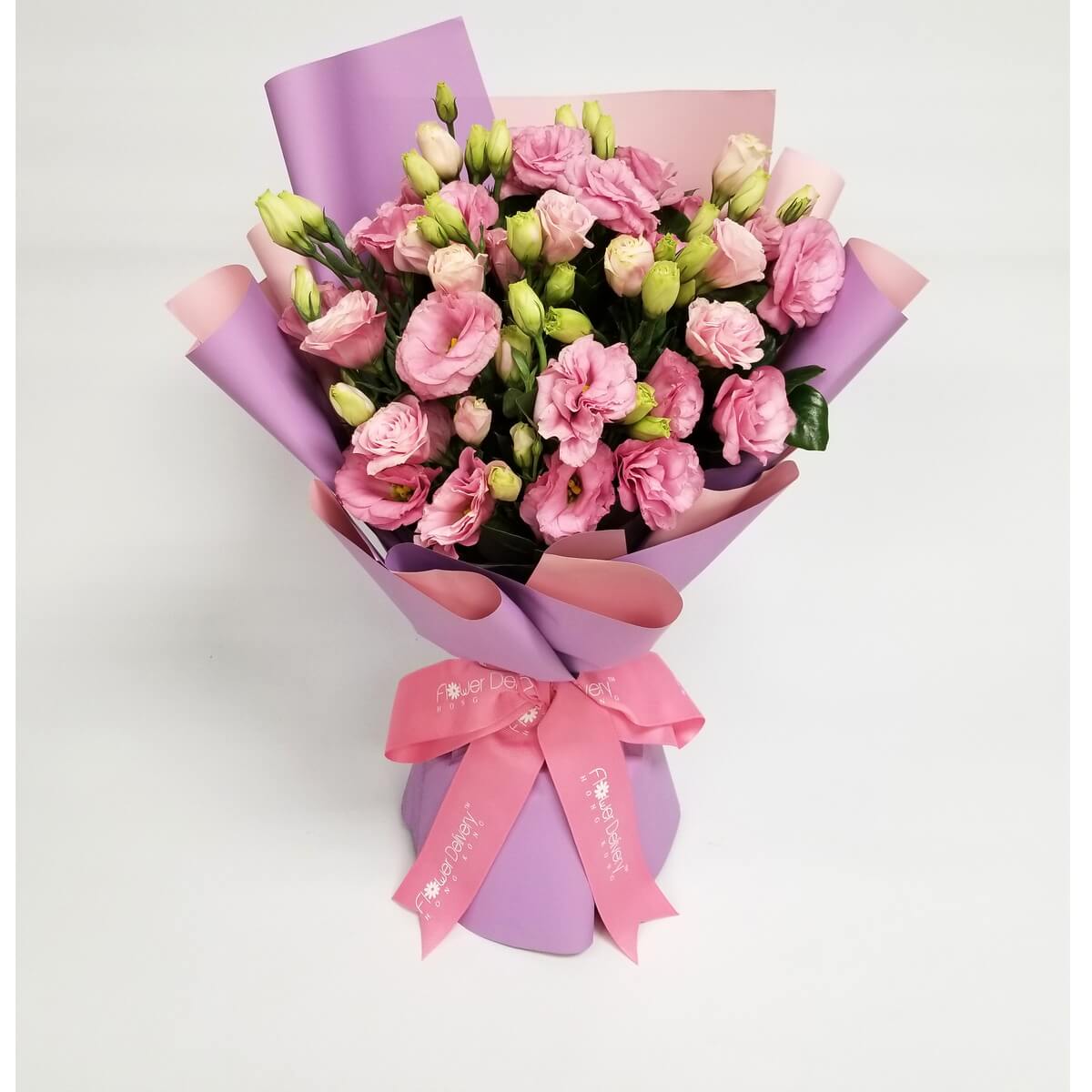 Full bouquet of blooming pink lisianthus and buds wrapped in layered lavender and blush pink paper 粉紅洋桔梗及花苞花束，外層以粉紅及薰衣草紫色包裝紙包裹，綁上同色絲帶。